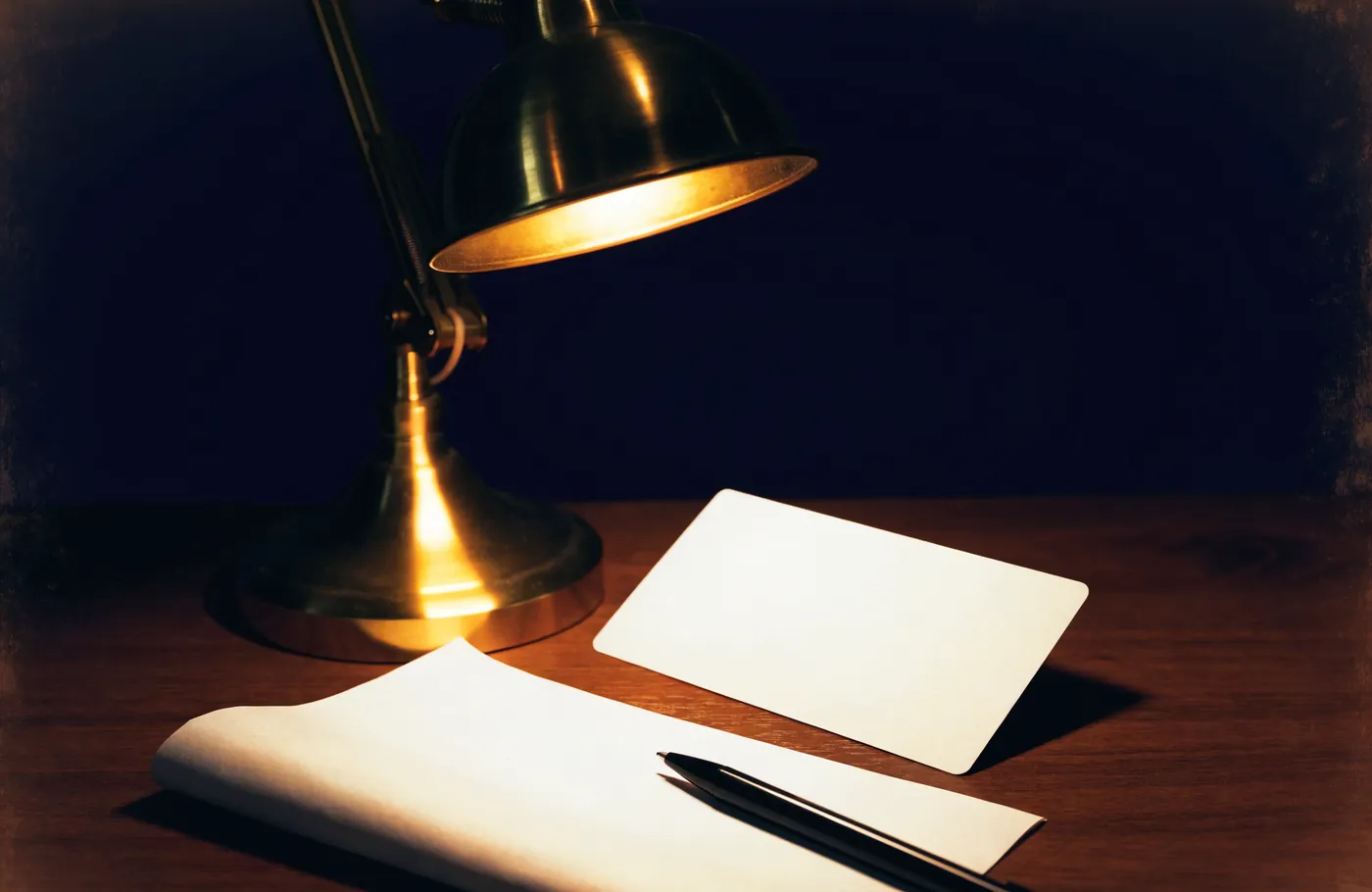 A payment card and a folded statement under a desk lamp
