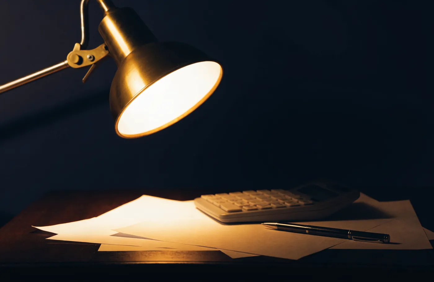 Des documents de pret et une calculatrice sous une lampe